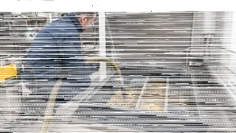 Técnico aspirando grasa y lodos de un separador en una cocina profesional.